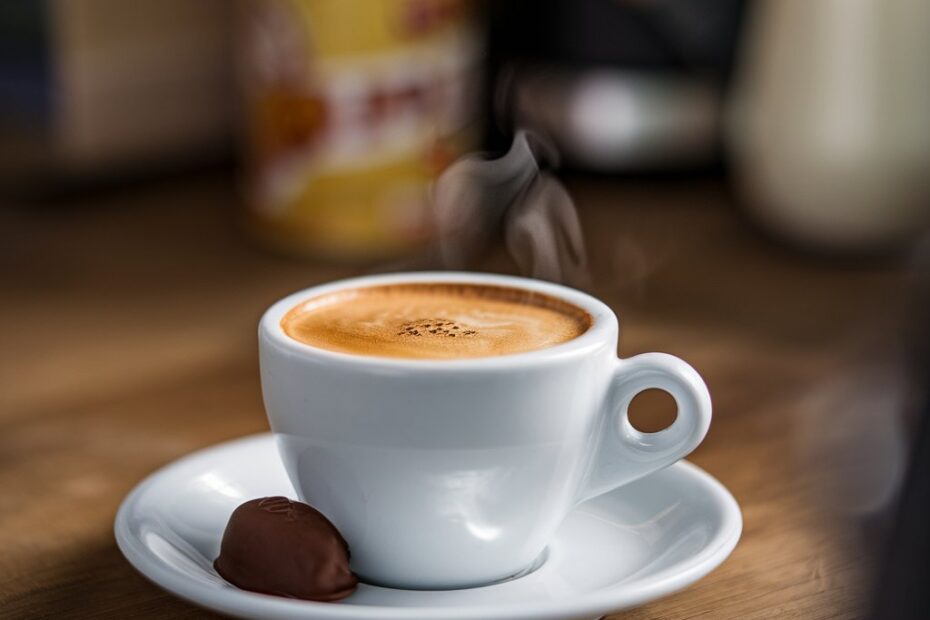 A steaming cup of fresh espresso with a rich golden crema on top.